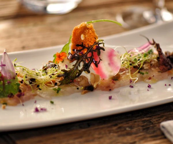 Entrée raffinée de sashimi de saumon sauvage à la japonaise aux fleurs comestibles, servi au Restaurant La Table de Trois à Bordeaux