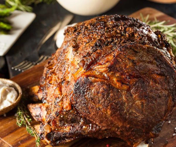 Souris d'agneau confite accompagnée de ses haricots Tarbais, servi sur une planche au restaurant La Table de Trois à Bordeaux